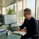 Il responsabile della privacy al lavoro nel suo ufficio privato, immerso nei documenti e nelle decisioni delicate.