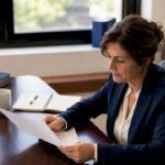 Imprenditrice che controlla un documento di certificazione nel suo ufficio