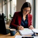 Una donna esamina attentamente un documento relativo alla gestione dei dati personali secondo il GDPR.