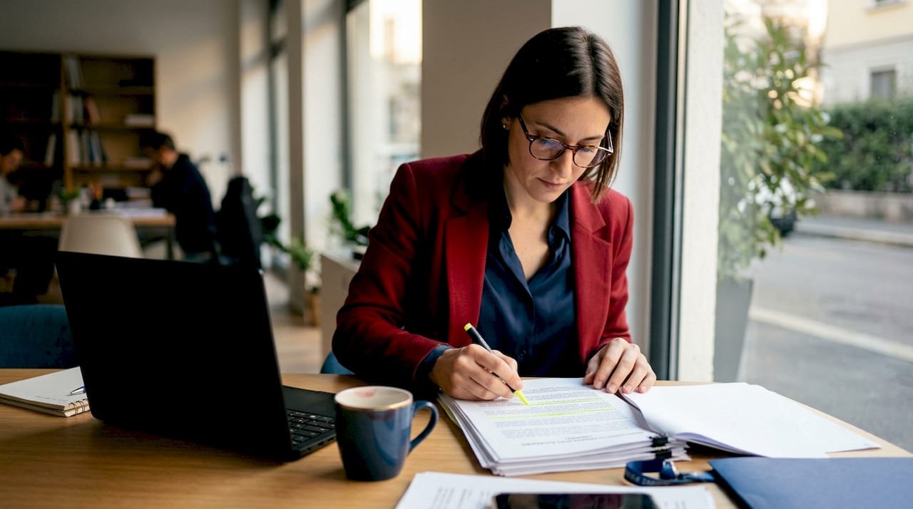 Una donna esamina attentamente un documento relativo alla gestione dei dati personali secondo il GDPR.