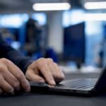 Mani che collegano un token di autenticazione a due fattori al laptop