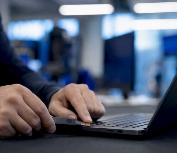 Mani che collegano un token di autenticazione a due fattori al laptop