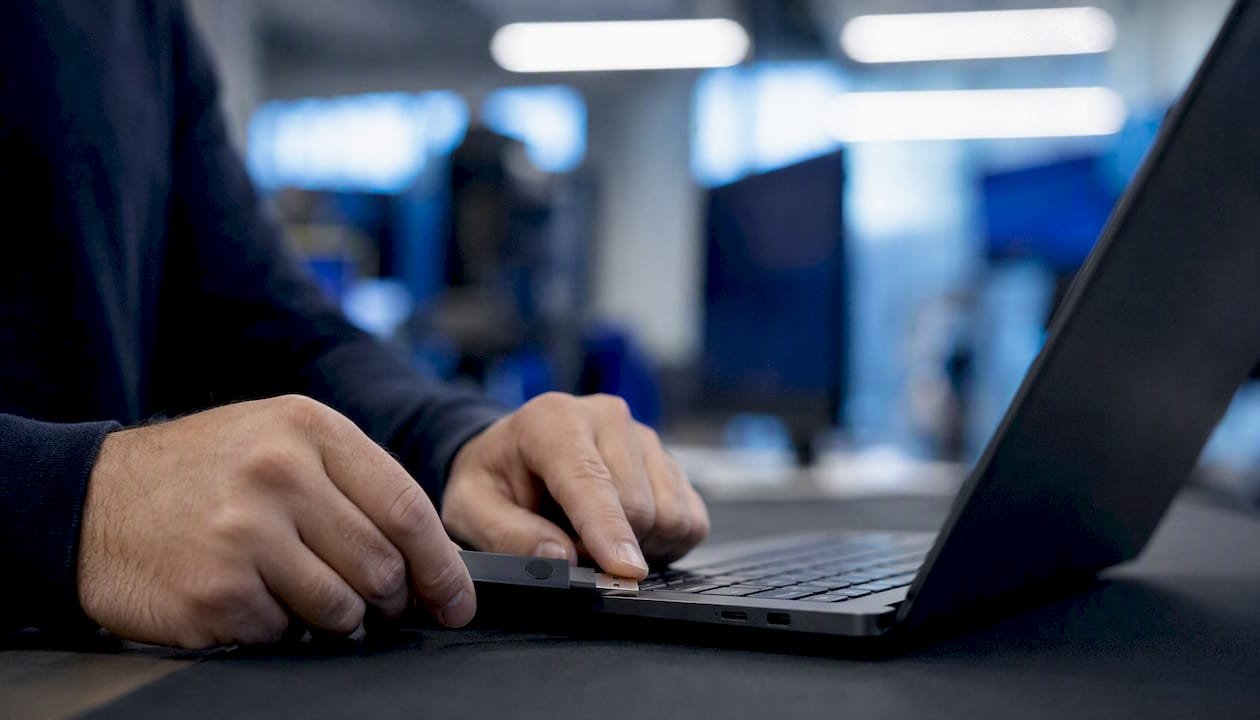 Mani che collegano un token di autenticazione a due fattori al laptop