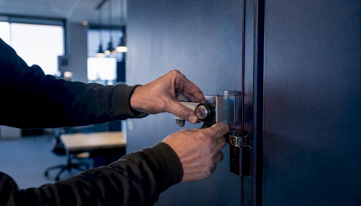 Mani che azionano la serratura di una cassaforte di sicurezza