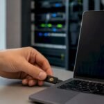 Mani che inseriscono una chiave di sicurezza nella porta USB di un portatile