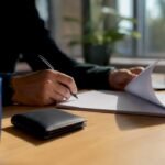 Mani che esaminano le clausole di un contratto sulla scrivania